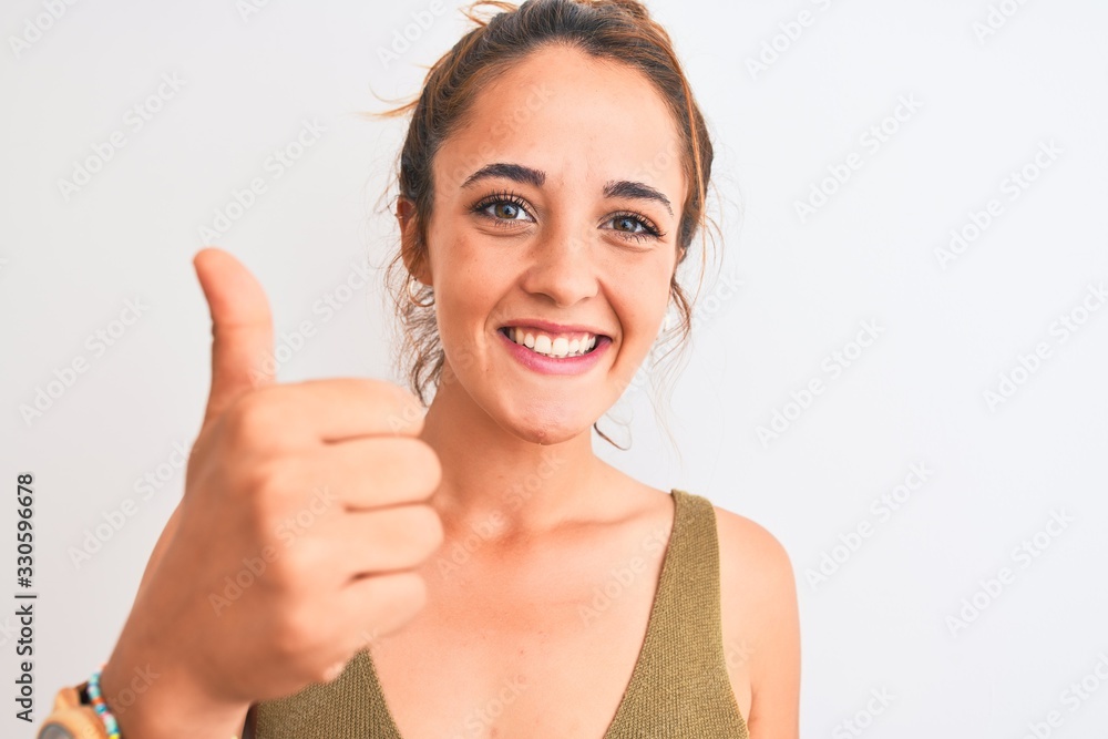 Young redhead woman wearing a bun over isolated background happy with big smile doing ok sign, thumb up with fingers, excellent sign Young redhead woman wearing a bun over isolated background happy with big smile doing ok sign, thumb up with fingers, excellent sign