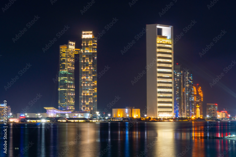 Fototapeta premium Nocny widok panoramy nowoczesnych drapaczy chmur Abu Dhabi. Luksusowe hotele i biznes w Zjednoczonych Emiratach Arabskich.