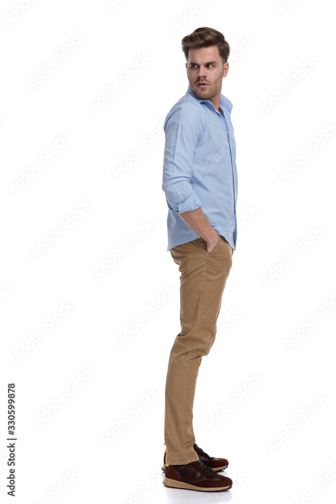 Fototapeta premium Side view of upset casual man looking over shoulder