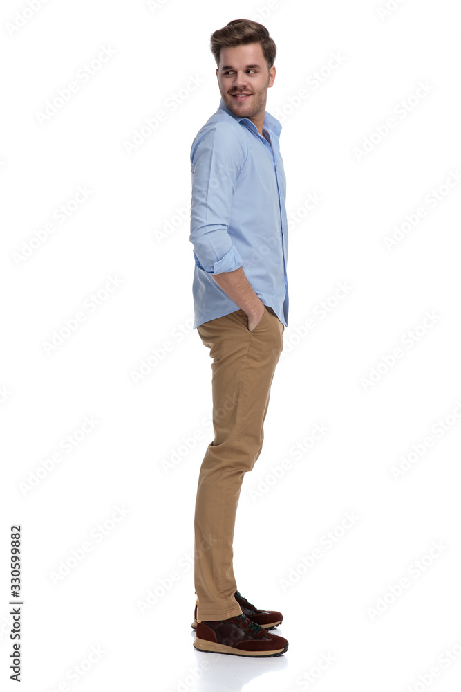 Side view of happy casual man looking over shoulder Side view of happy casual man looking over shoulder