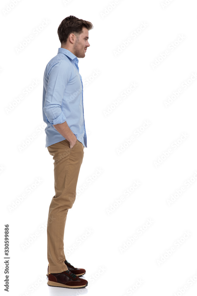 Fototapeta premium Side view of casual man holding both hands in pockets
