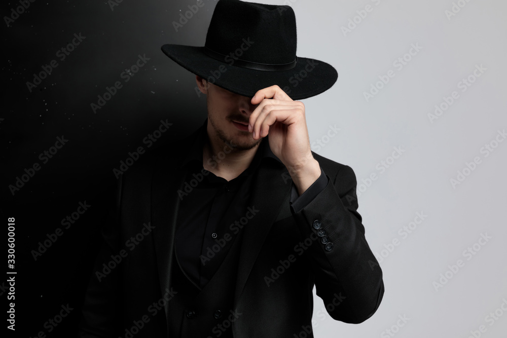 Mysterious fashion model greeting and covering his eyes Mysterious fashion model greeting and covering his eyes