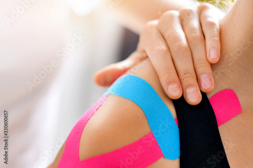 Canvastavla Kinesiology taping treatment with blue and pink tape on athlete patient injured arm