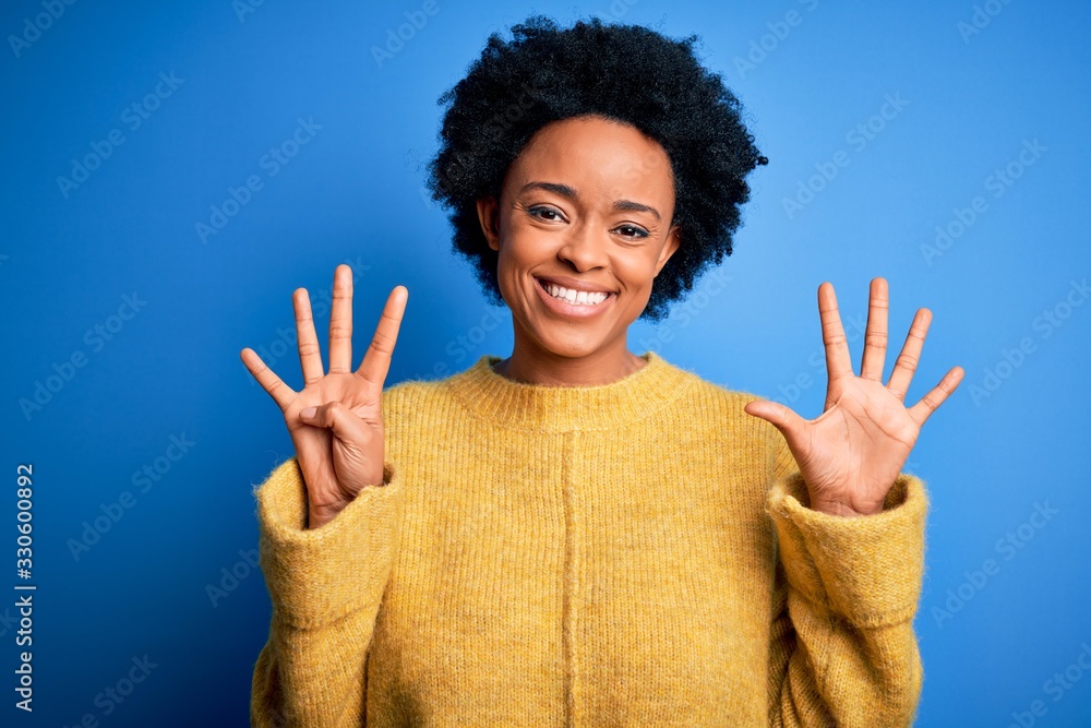 Young beautiful African American afro woman with curly hair wearing yellow casual sweater showing and pointing up with fingers number nine while smiling confident and happy. Young beautiful African American afro woman with curly hair wearing yellow casual sweater showing and pointing up with fingers number nine while smiling confident and happy.
