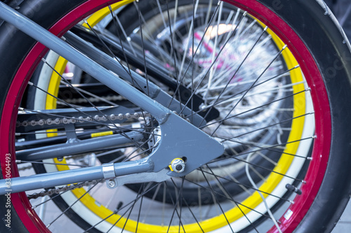 red rear bicycle wheel close-up on a blurred background of the yellow rim of another bicycle