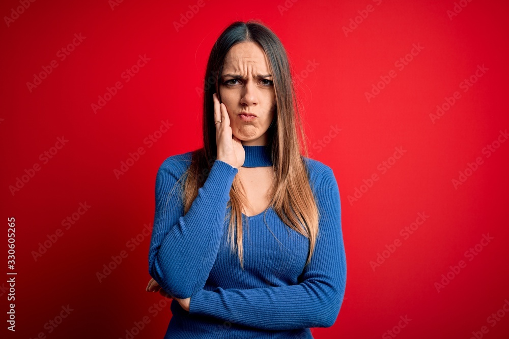 Young beautiful blonde woman with blue eyes standing over red background thinking looking tired and bored with depression problems with crossed arms. Young beautiful blonde woman with blue eyes standing over red background thinking looking tired and bored with depression problems with crossed arms.