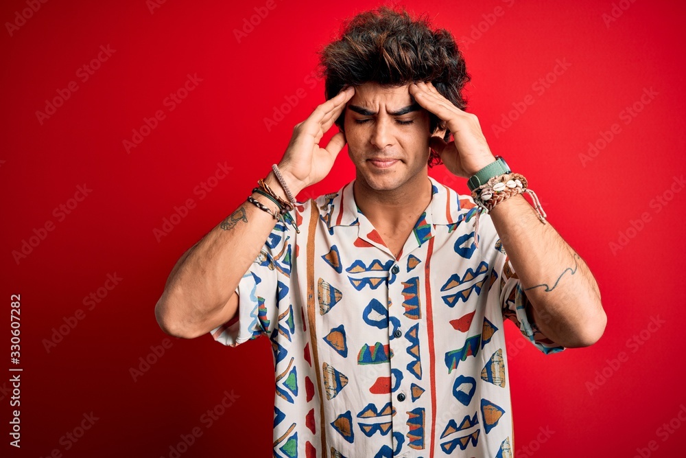 Young handsome man on vacation wearing summer shirt over isolated red background with hand on headache because stress. Suffering migraine. Young handsome man on vacation wearing summer shirt over isolated red background with hand on headache because stress. Suffering migraine.
