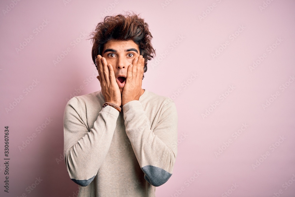 Young handsome man wearing casual t-shirt standing over isolated pink background afraid and shocked, surprise and amazed expression with hands on face Young handsome man wearing casual t-shirt standing over isolated pink background afraid and shocked, surprise and amazed expression with hands on face