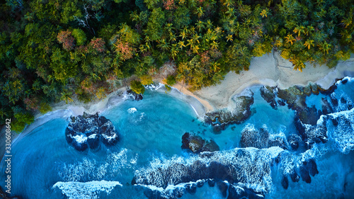 Magnificent aerial shot of a blue tropic lagoon with crystal clear water surrounded by beach and palm trees. photo