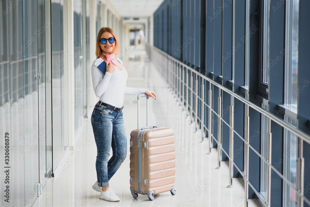 Woman walking with suitcase on the airport terminal,travel concept. High season and vacation concept. Relax and lifestyles. Travel and Holiday Concept.