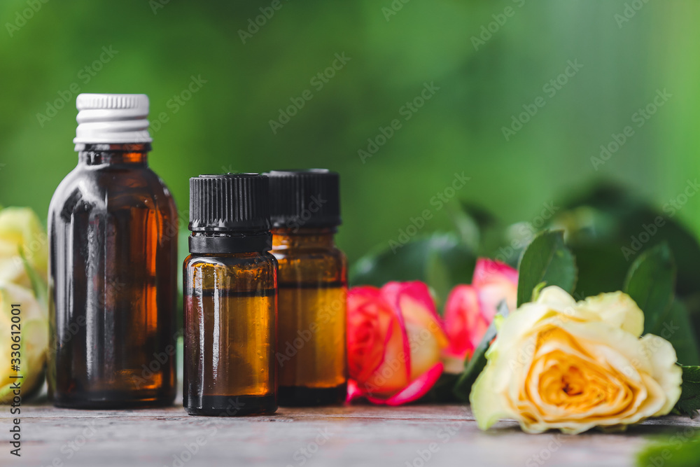 Bottles of rose essential oil on table Bottles of rose essential oil on table