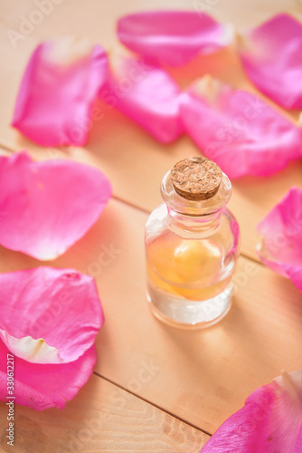 Bottle of rose essential oil on table