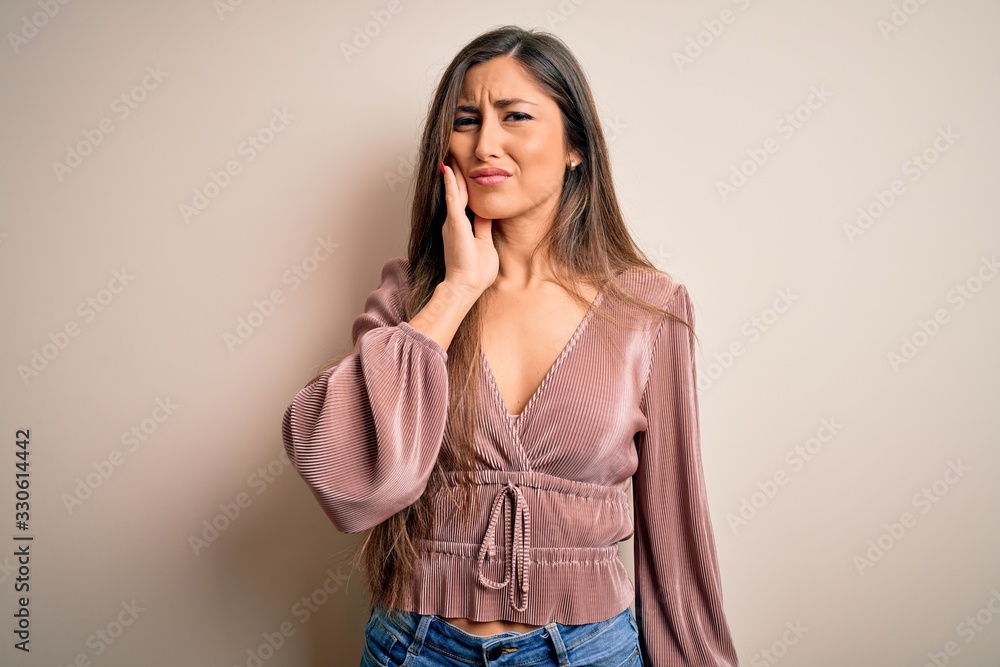 Young beautiful brunette elegant woman with long hair standing over isolated background touching mouth with hand with painful expression because of toothache or dental illness on teeth. Dentist Young beautiful brunette elegant woman with long hair standing over isolated background touching mouth with hand with painful expression because of toothache or dental illness on teeth. Dentist