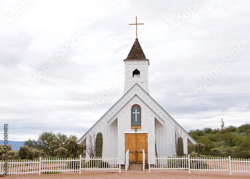 Принти на полотні Small rustic white church in desert landscape with white picket fence around it