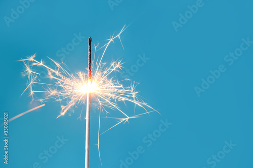 Beautiful Christmas sparkler on color background photo