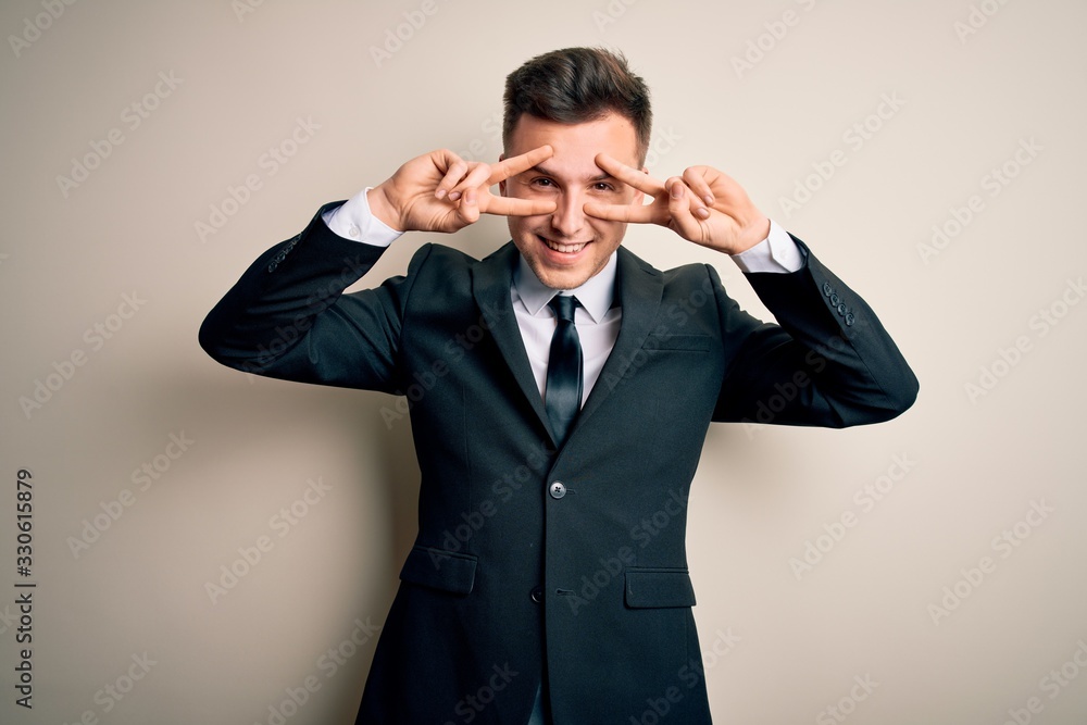 Young handsome business man wearing elegant suit and tie over isolated background Doing peace symbol with fingers over face, smiling cheerful showing victory Young handsome business man wearing elegant suit and tie over isolated background Doing peace symbol with fingers over face, smiling cheerful showing victory