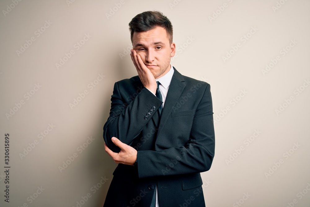Young handsome business man wearing elegant suit and tie over isolated background thinking looking tired and bored with depression problems with crossed arms. Young handsome business man wearing elegant suit and tie over isolated background thinking looking tired and bored with depression problems with crossed arms.