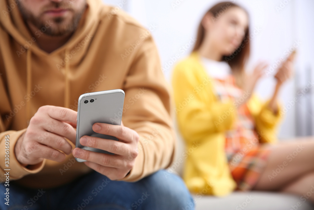 Man with smartphone ignoring his girlfriend at home, closeup. Relationship problems Man with smartphone ignoring his girlfriend at home, closeup. Relationship problems