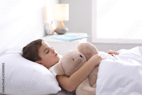 Little boy sleeping with teddy bear at home. Bedtime