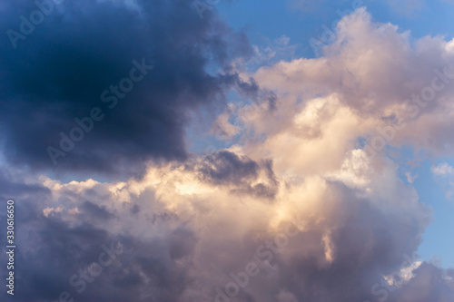 Dramatic storm dark and white cumulus clouds in sunlight on blue sky background texture  © Viktor Iden