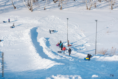 a lot of people ride a tubenge. skiing from the mountain in winter.