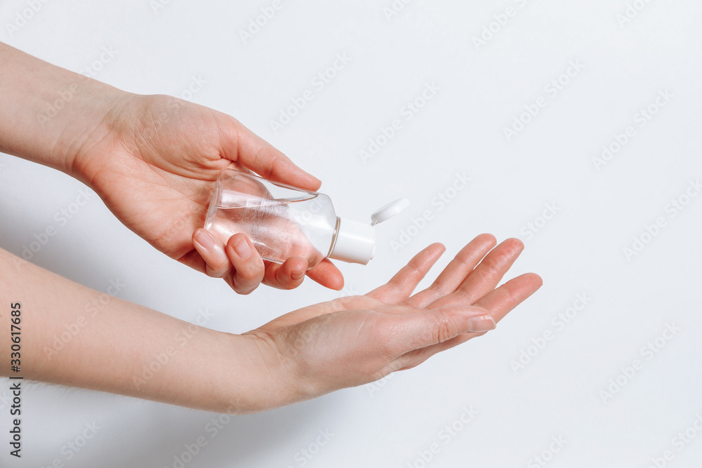 Applying alcohol sanitizer gel or antibacterial gel at female arm to prevent spread of virus, bacteria and coronavirus. Hygiene supplies at white background. Personal hygiene disinfectant concept. Applying alcohol sanitizer gel or antibacterial gel at female arm to prevent spread of virus, bacteria and coronavirus. Hygiene supplies at white background. Personal hygiene disinfectant concept.