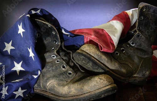 Closeup of old combat boots and an American flag.