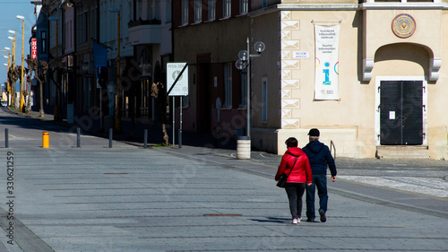 TRNAVA, SLOVAKIA - 2020, March 15th - An older couple walking on the empty streets in Trnava, Slovakia. Social gatherings must be minimized according to the Slovak government.