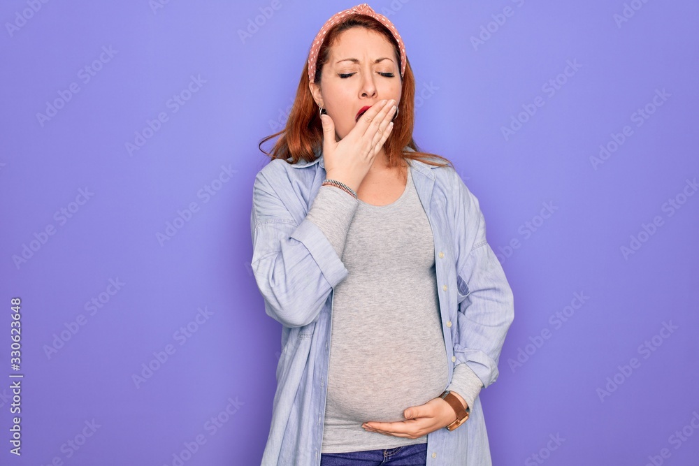 Young beautiful redhead pregnant woman expecting baby over isolated purple background bored yawning tired covering mouth with hand. Restless and sleepiness. Young beautiful redhead pregnant woman expecting baby over isolated purple background bored yawning tired covering mouth with hand. Restless and sleepiness.