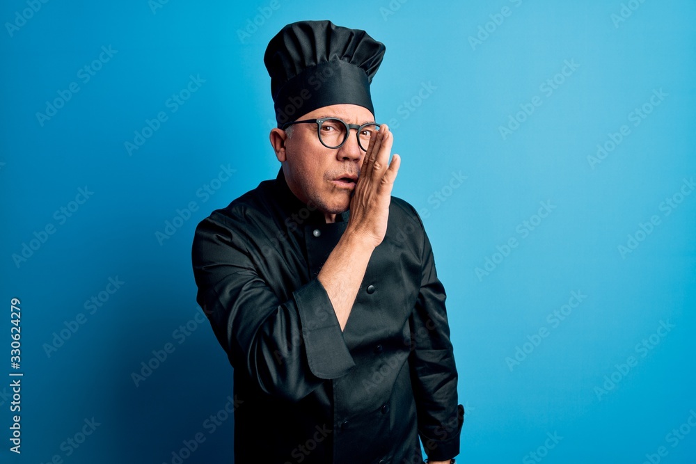 Middle age handsome grey-haired chef man wearing cooker uniform and hat hand on mouth telling secret rumor, whispering malicious talk conversation Middle age handsome grey-haired chef man wearing cooker uniform and hat hand on mouth telling secret rumor, whispering malicious talk conversation