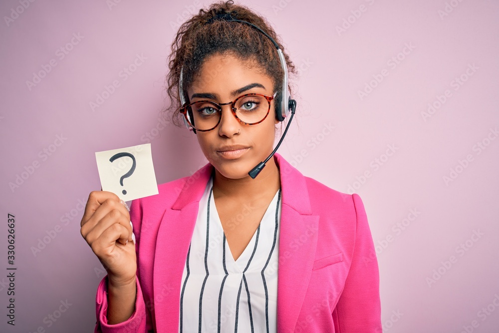 African american call center agent girl working using headset holding question mark symbol with a confident expression on smart face thinking serious African american call center agent girl working using headset holding question mark symbol with a confident expression on smart face thinking serious