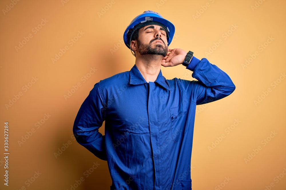 Foto de Mechanic man with beard wearing blue uniform and safety helmet