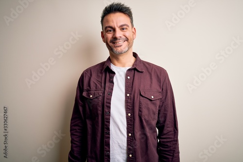 Young handsome man wearing casual shirt standing over isolated white background with a happy and cool smile on face. Lucky person. © Krakenimages.com