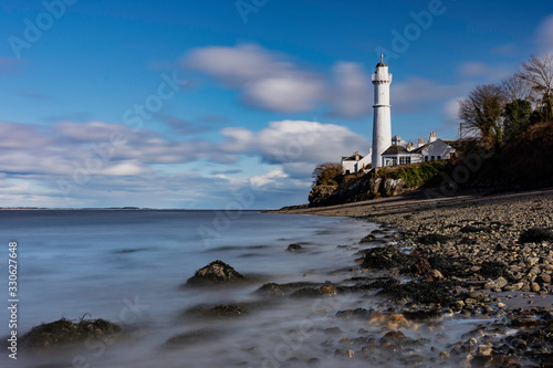 light house at tayport fie scotland with silky water on shoreline.