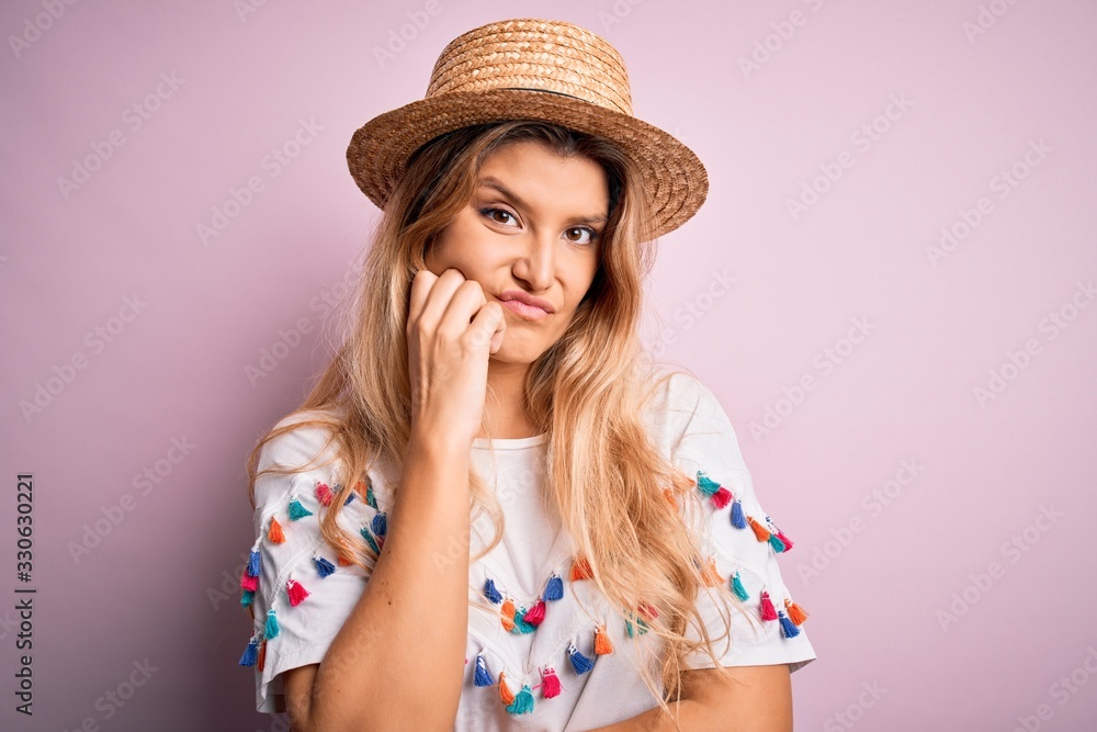 Young beautiful blonde woman wearing t-shirt and hat over isolated pink background thinking looking tired and bored with depression problems with crossed arms. Young beautiful blonde woman wearing t-shirt and hat over isolated pink background thinking looking tired and bored with depression problems with crossed arms.