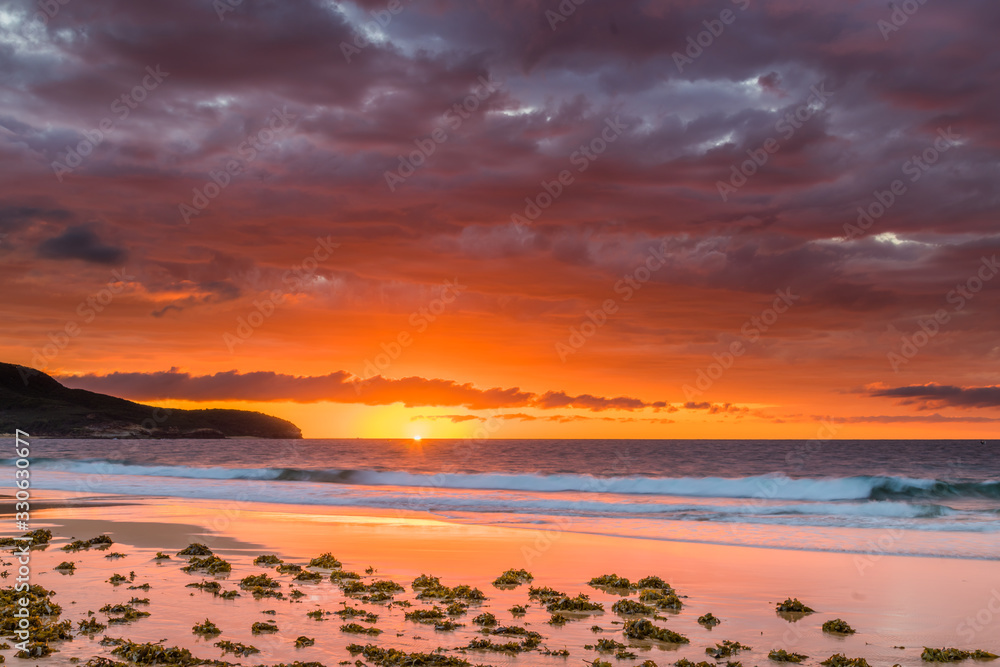 Obraz premium Clouds, rocks and the sea creating an atmospheric Sunrise Seascape