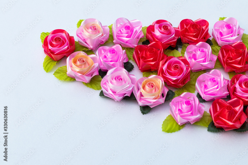 Artificial pink roses red on a white background.