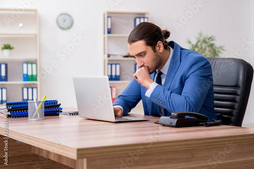 Young male businessman employee working in the office