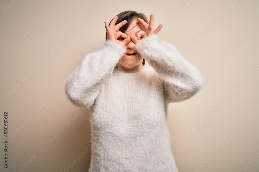 Young down syndrome woman standing over isolated background doing ok gesture like binoculars sticking tongue out, eyes looking through fingers. Crazy expression. Young down syndrome woman standing over isolated background doing ok gesture like binoculars sticking tongue out, eyes looking through fingers. Crazy expression.