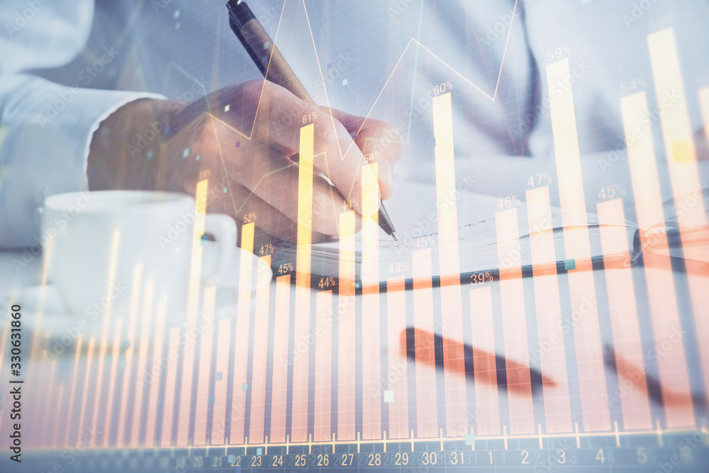 Double exposure of man's hands writing notes of stock market with forex chart. Double exposure of man's hands writing notes of stock market with forex chart.