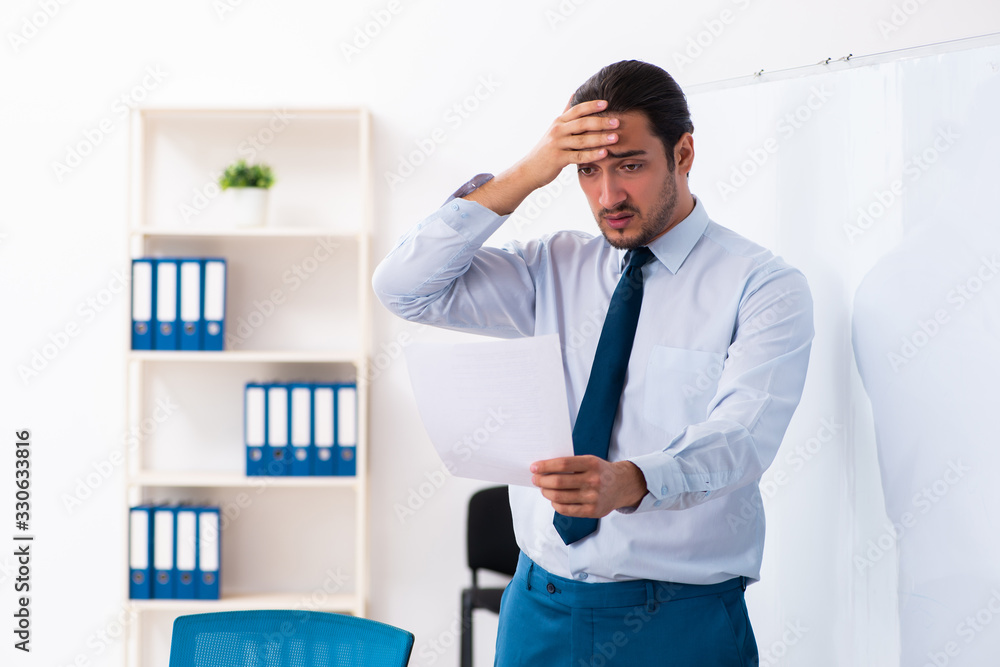 Young male employee in business presentation concept Young male employee in business presentation concept