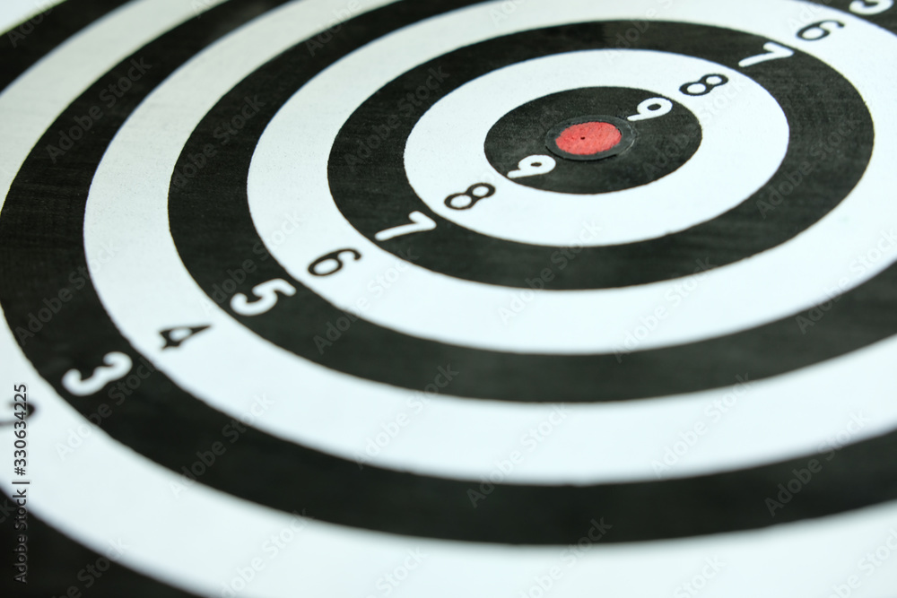 Conceptual photo of business strategy / accuracy - a red arrow that sticks directly in the center of the target dartboard Conceptual photo of business strategy / accuracy - a red arrow that sticks directly in the center of the target dartboard