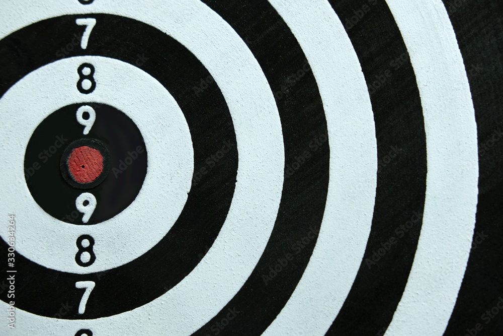 Conceptual photo of business strategy / accuracy - a red arrow that sticks directly in the center of the target dartboard Conceptual photo of business strategy / accuracy - a red arrow that sticks directly in the center of the target dartboard