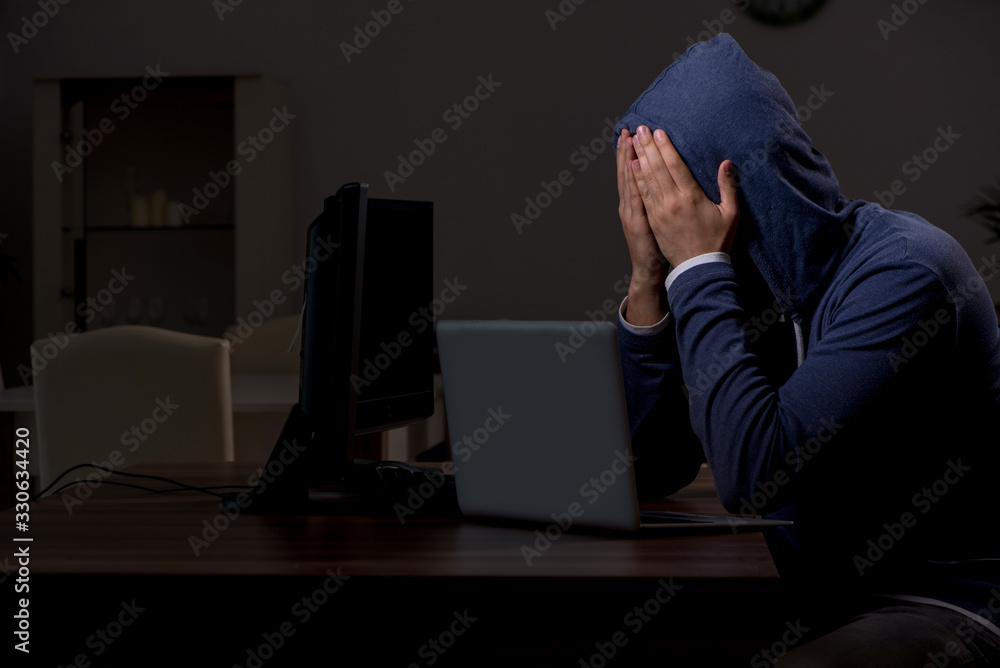 Male hacker hacking security firewall late in office Male hacker hacking security firewall late in office