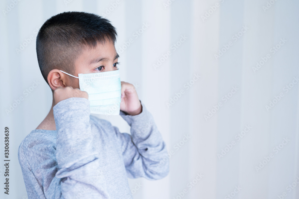 Portrait Asian kid wearing medical mask.A boy wearing mouth mask against air smog pollution. Concept of corona virus quarantine or covid-19.Protection against virus and infection control concept.