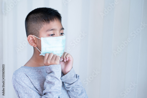 Portrait Asian kid wearing medical mask.A boy wearing mouth mask against air smog pollution. Concept of corona virus quarantine or covid-19.Protection against virus and infection control concept.