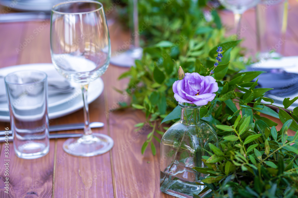 Beautifully decorated wooden table in a summer open-air cafe. Green branch and fresh flowers table decoration Beautifully decorated wooden table in a summer open-air cafe. Green branch and fresh flowers table decoration