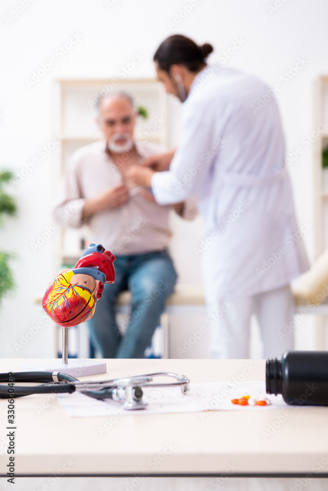 Old man visiting young male doctor cardiologist Old man visiting young male doctor cardiologist