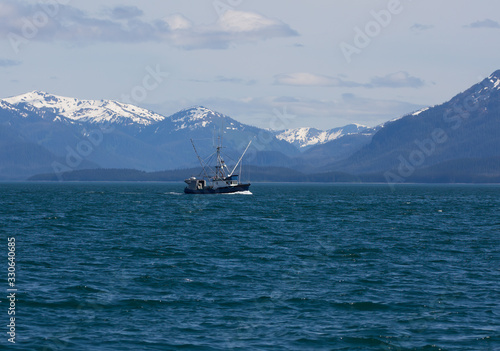 Salmon fishing boat in Southeast Alaska with mountains