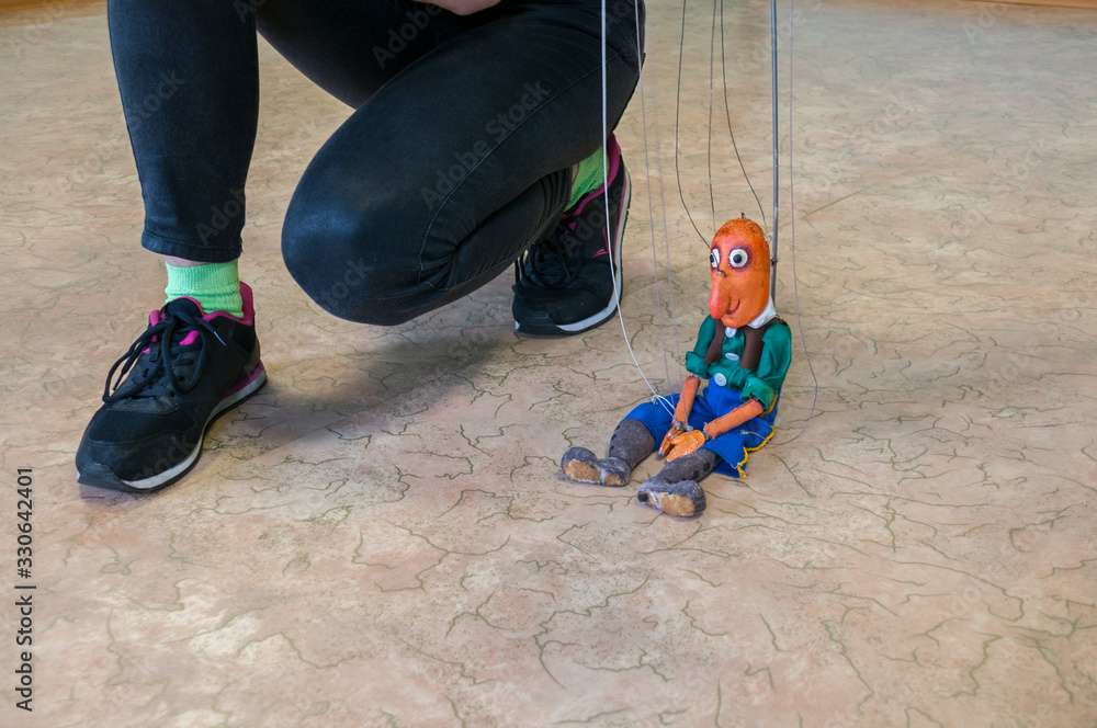 Russia, Blagoveshchensk, July 2019:Puppet puppet and puppeteer's legs